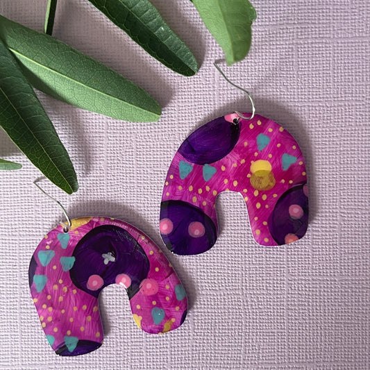 Colourful purple earrings in arch shape