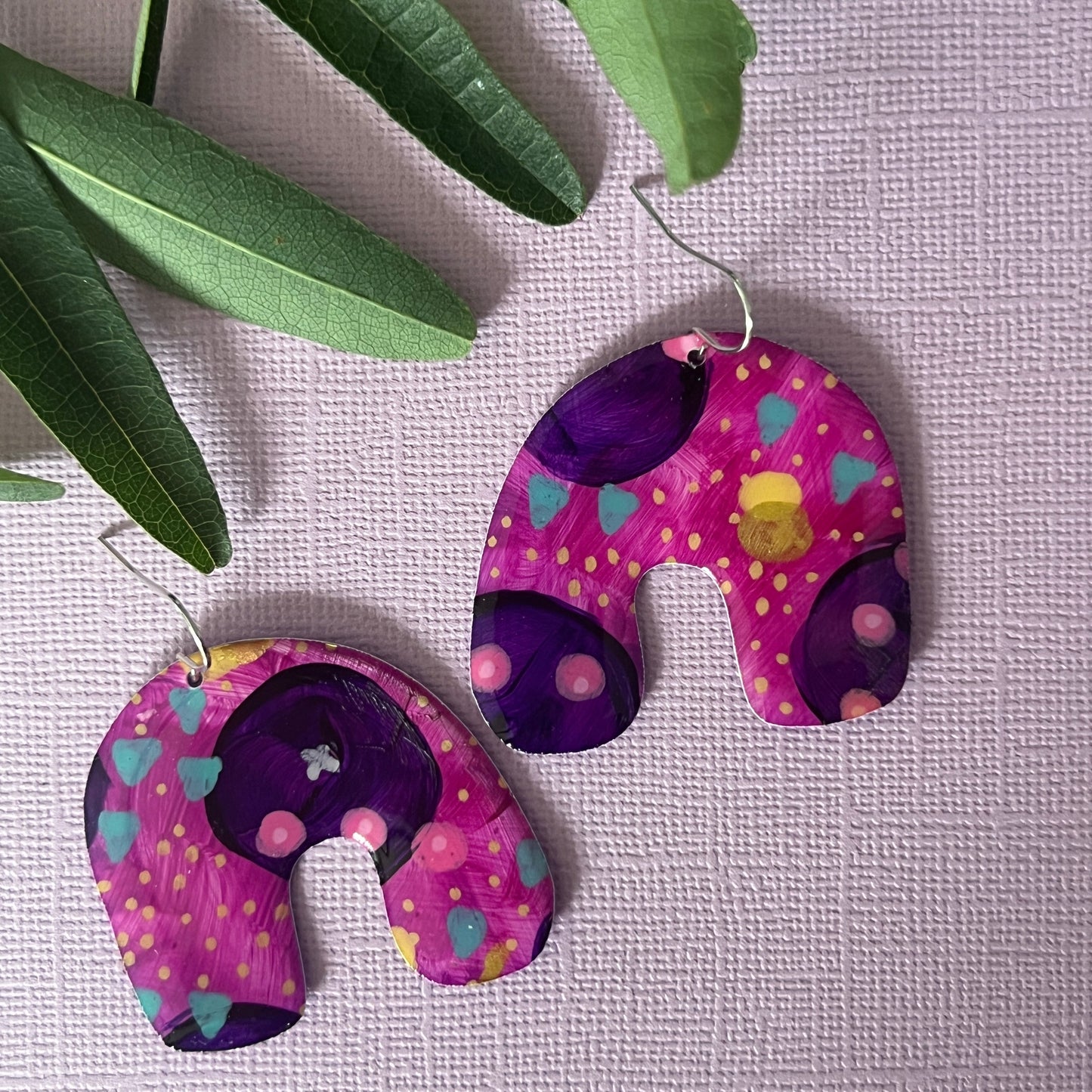 Colourful purple earrings in arch shape