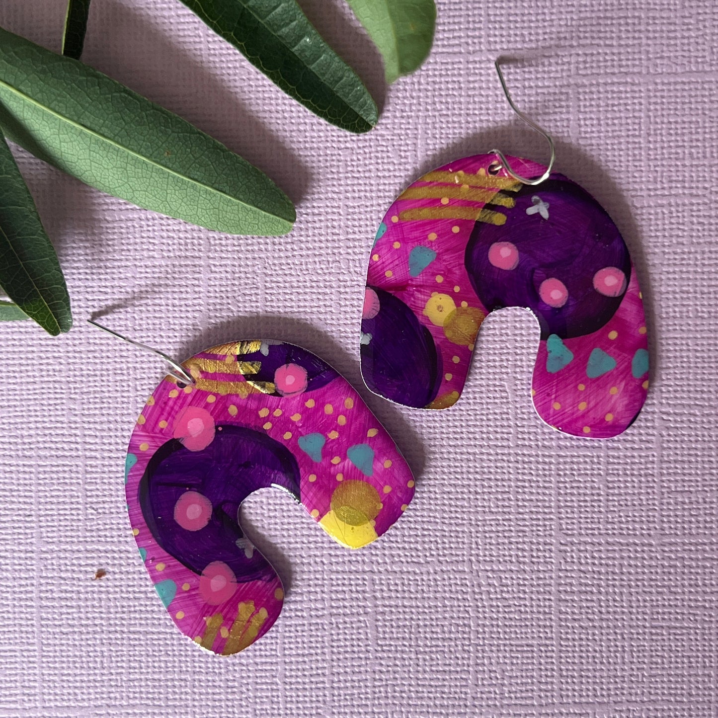 Pair of colourful earrings in purple, in arch shape